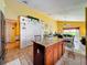 A kitchen boasting granite counters, central island, tile floors, and bright, cheery yellow walls at 7939 Riffle Ln, Orlando, FL 32818
