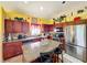 An open-concept kitchen featuring updated stainless steel appliances, granite counters, and wood cabinetry at 7939 Riffle Ln, Orlando, FL 32818