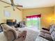 A living room with comfortable seating, a large TV, and sliding glass doors to the backyard at 7939 Riffle Ln, Orlando, FL 32818