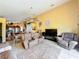 Cozy living room with a vaulted ceiling, comfortable seating, and bright yellow walls at 7939 Riffle Ln, Orlando, FL 32818