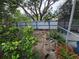 Backyard view with tall bushes, plants along a white and blue fence at 8603 Snowfire Dr, Orlando, FL 32818