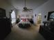 Cozy bedroom with carpet, a ceiling fan, a comfortable bed, and matching lamps at 8603 Snowfire Dr, Orlando, FL 32818