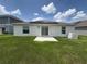 Back exterior of home, showcasing a concrete patio and solar panels at 873 Daring Dr, Davenport, FL 33837