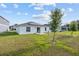 Expansive backyard featuring a patio with chairs, lush lawn, and modern home with solar panels at 873 Daring Dr, Davenport, FL 33837