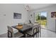 Bright dining room with a dark wood table, stylish light fixture, and sliding glass doors to the backyard at 873 Daring Dr, Davenport, FL 33837