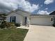 Charming single-story home with a well-manicured lawn, blue door, and two car garage at 873 Daring Dr, Davenport, FL 33837