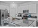 A modern kitchen features stainless steel appliances, stylish gray countertops and crisp white cabinets at 873 Daring Dr, Davenport, FL 33837