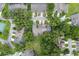 Aerial view of neighborhood showcasing mature trees, landscaping, and surrounding homes at 8932 Village Green Blvd, Clermont, FL 34711