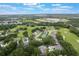 Aerial view of a vibrant community with lush greenery, featuring golf courses, ponds and various housing options at 8932 Village Green Blvd, Clermont, FL 34711