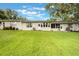 Wide backyard showcasing lush green lawn and the home's exterior at 8932 Village Green Blvd, Clermont, FL 34711
