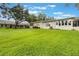 Backyard with a manicured lawn and mature trees, ideal for outdoor activities at 8932 Village Green Blvd, Clermont, FL 34711