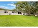 Exterior view of the home highlighting the spacious backyard and natural light at 8932 Village Green Blvd, Clermont, FL 34711