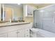 Bathroom featuring granite counters, white cabinets, and a shower-tub combo at 8932 Village Green Blvd, Clermont, FL 34711