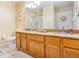 Bathroom with dual sinks, granite counters, and a walk-in shower at 8932 Village Green Blvd, Clermont, FL 34711