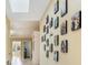 Light-filled hallway with decorative photo gallery and tile flooring, leading to other rooms at 8932 Village Green Blvd, Clermont, FL 34711