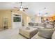 Inviting living room features vaulted ceilings, tile floors, and a comfortable sectional sofa at 8932 Village Green Blvd, Clermont, FL 34711