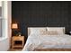 Comfortable bedroom featuring a decorative wall, wood nightstand, and a plush white comforter at 9201 Smithies St, Orlando, FL 32827