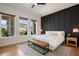 Well-lit bedroom with a decorative wall, three large windows, and a padded bench at the foot of the bed at 9201 Smithies St, Orlando, FL 32827