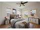 Cozy bedroom with a stylish accent wall, complemented by ample natural light from large windows at 9201 Smithies St, Orlando, FL 32827