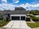 Detached two-car garage with an expansive driveway, complemented by a patio with table and chairs at 9201 Smithies St, Orlando, FL 32827