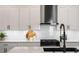 This kitchen features white cabinets, a stainless steel range hood, gas cooktop, white subway tile, and quartz countertops at 9201 Smithies St, Orlando, FL 32827