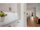 This kitchen features white shaker cabinets, quartz countertop, tiled backsplash and opens to the main living space at 9201 Smithies St, Orlando, FL 32827