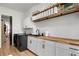 Modern laundry room with wood counters, white cabinets, and modern black appliances at 9201 Smithies St, Orlando, FL 32827