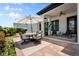 Covered patio with an outdoor dining table with umbrella and comfortable seating areas at 9201 Smithies St, Orlando, FL 32827