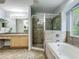 Bright bathroom with a glass-enclosed shower, soaking tub, and a large vanity at 9454 Candice Ct, Orlando, FL 32832