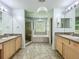 A stylish primary bathroom boasts double vanities, a soaking tub, and a separate glass shower enclosure at 9454 Candice Ct, Orlando, FL 32832
