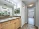 Bathroom with double sinks, vanity, and a large mirror with bright vanity lighting at 9454 Candice Ct, Orlando, FL 32832