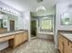 Spacious bathroom with double vanities, tile flooring, walk-in shower, and large soaking tub at 9454 Candice Ct, Orlando, FL 32832