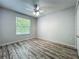 Bedroom with gray wood-look flooring, a ceiling fan, and a bright window at 9454 Candice Ct, Orlando, FL 32832