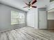 Bright bedroom featuring wood-look floors, a ceiling fan, large window and a double-door closet at 9454 Candice Ct, Orlando, FL 32832