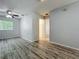 Spacious bedroom with ceiling fan, light gray walls, wood-look flooring, and a bright window at 9454 Candice Ct, Orlando, FL 32832