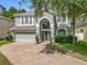 Stunning two-story home featuring a brick driveway, two-car garage, and beautifully landscaped front yard at 9454 Candice Ct, Orlando, FL 32832