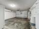 View of an empty garage with a roll-up door, white walls, and visible storage racks at 9454 Candice Ct, Orlando, FL 32832