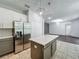 Well-lit kitchen with a stainless steel fridge, tiled floors, and an island, open to the dining and living area at 9454 Candice Ct, Orlando, FL 32832