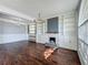 Cozy living room featuring a fireplace, built-in shelving, wainscotting, and modern chandelier at 9454 Candice Ct, Orlando, FL 32832