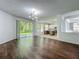Bright, open-concept living room with dark hardwood floors and sliding glass doors to the backyard at 9454 Candice Ct, Orlando, FL 32832