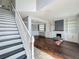 Spacious living room with a fireplace, custom built-ins, hardwood floors, and a staircase to the second floor at 9454 Candice Ct, Orlando, FL 32832
