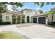 Elegant Mediterranean home with a red tile roof, striking blue garage doors, and brick paved driveway at 9809 Covent Garden Dr # Drive, Orlando, FL 32827