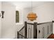 Hallway with black staircase railing, natural woven chandelier, and window with dark trim at 9809 Covent Garden Dr # Drive, Orlando, FL 32827