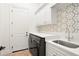 Functional laundry room with modern appliances, storage cabinets, and a convenient utility sink at 9809 Covent Garden Dr # Drive, Orlando, FL 32827