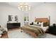 Bedroom with a wood-toned bed, modern chandelier, and black dresser at 9809 Covent Garden Dr # Drive, Orlando, FL 32827