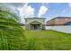 A lush backyard with green grass and privacy, framed by a perimeter fence and a peekaboo palm at 1951 Betsy Ross Ln, St Cloud, FL 34769