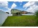 A spacious backyard with a well-manicured lawn, framed by a bright, white fence for privacy at 1951 Betsy Ross Ln, St Cloud, FL 34769
