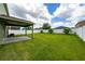 An expansive backyard features healthy green grass, a privacy fence, and a covered outdoor patio at 1951 Betsy Ross Ln, St Cloud, FL 34769