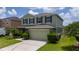 Charming two-story home featuring lush landscaping, an attached two car garage, and an inviting facade at 1951 Betsy Ross Ln, St Cloud, FL 34769