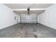 An empty, clean garage with a gray concrete floor and a partially open, paneled garage door at 1951 Betsy Ross Ln, St Cloud, FL 34769